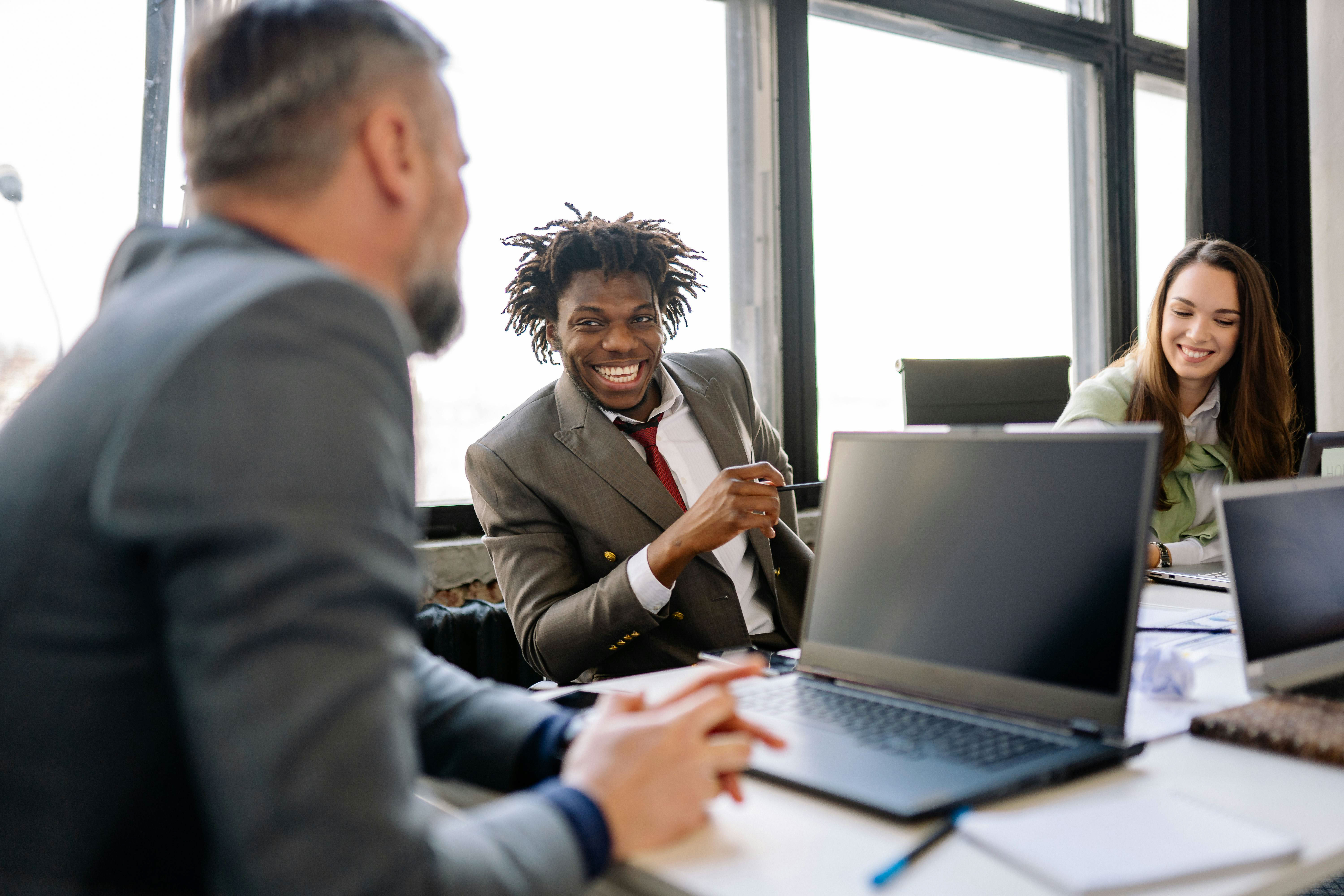 A group of professionals from top expert networks talk and work with a new private equity firm client around a work table.