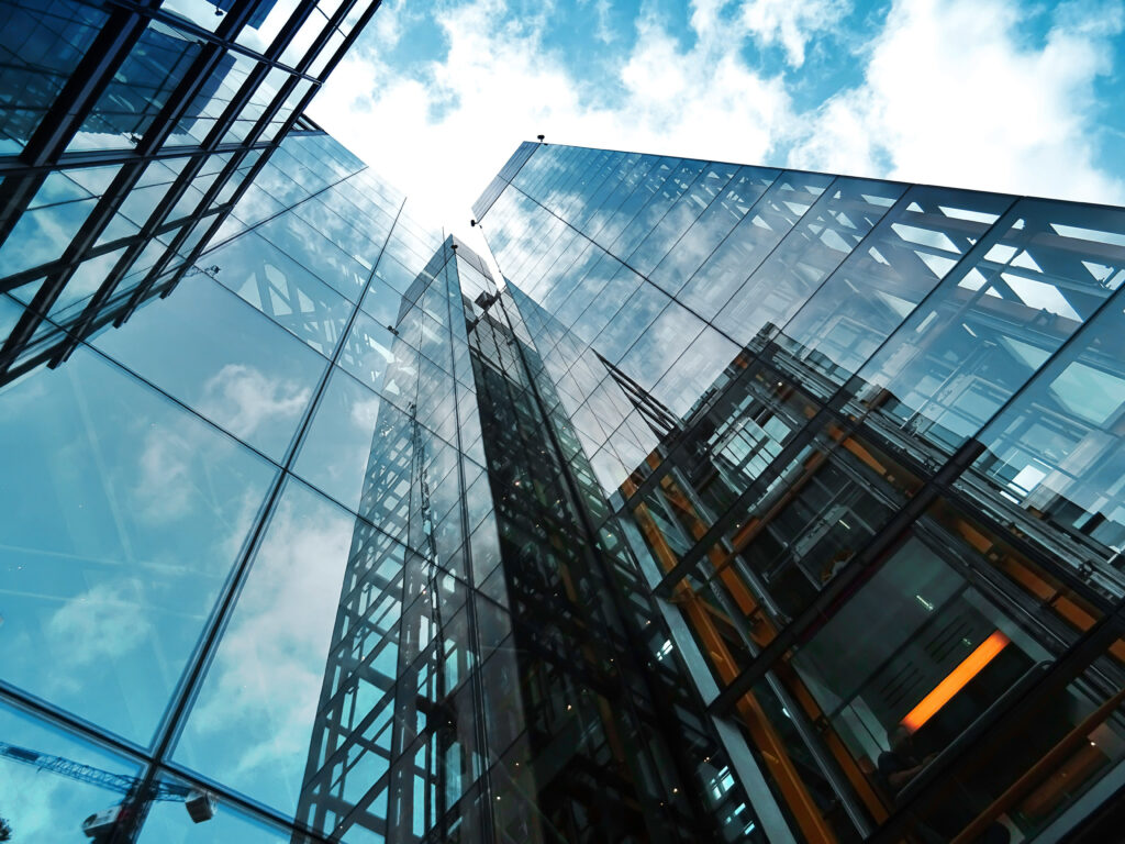 Skyscrapers reflecting the sky, symbolizing the rise of digitalization and smart factories in manufacturing industry trends.